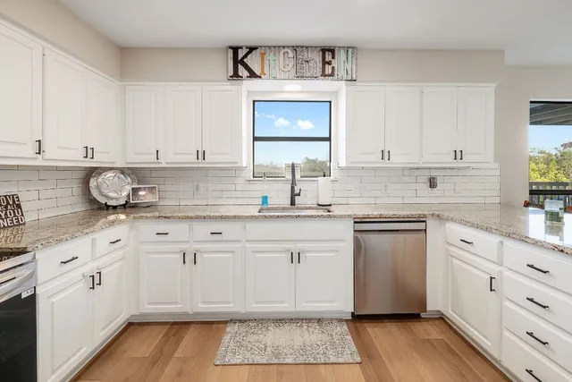 a kitchen with granite countertop white cabinets and white appliances