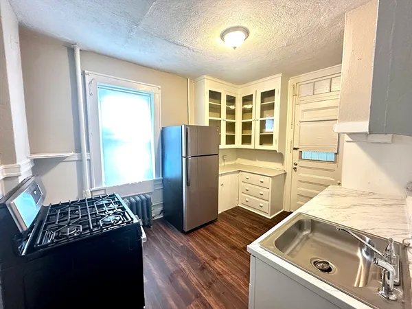a kitchen that has a sink stove and refrigerator