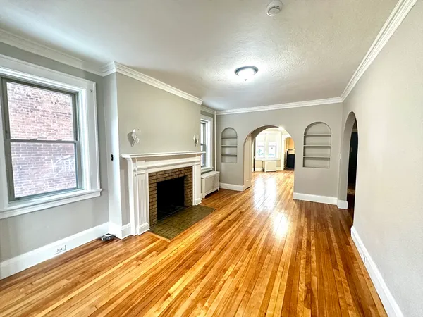 a view of empty room with wooden floor and fireplace