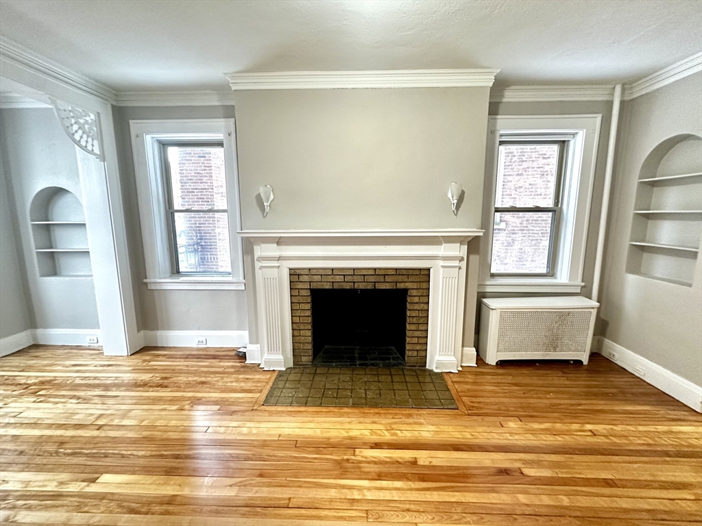 577 Pleasant Street, Unit 1L Holyoke, MA 01040 - Photo 13 of 24 a view of a livingroom with a fireplace window and wooden floor
