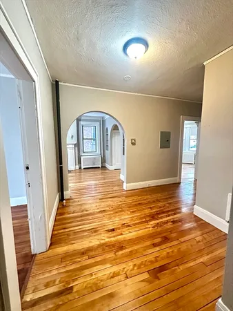a view of empty room with window and wooden floor