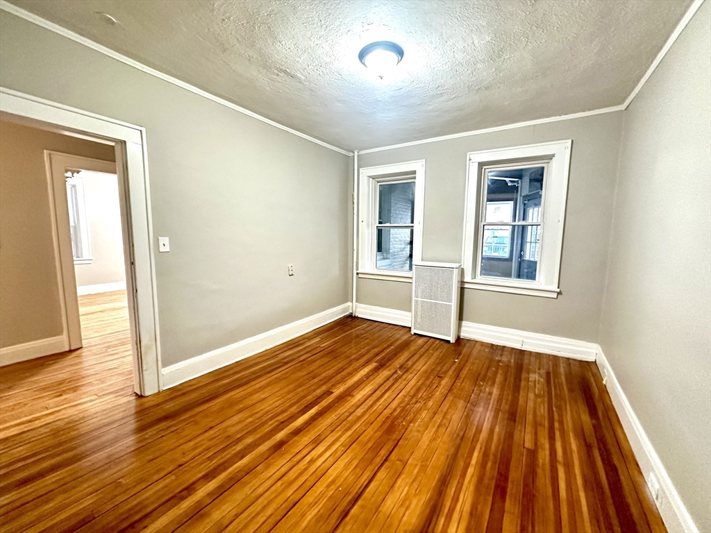 577 Pleasant Street, Unit 1L Holyoke, MA 01040 - Photo 19 of 24 wooden floor in an empty room with a window