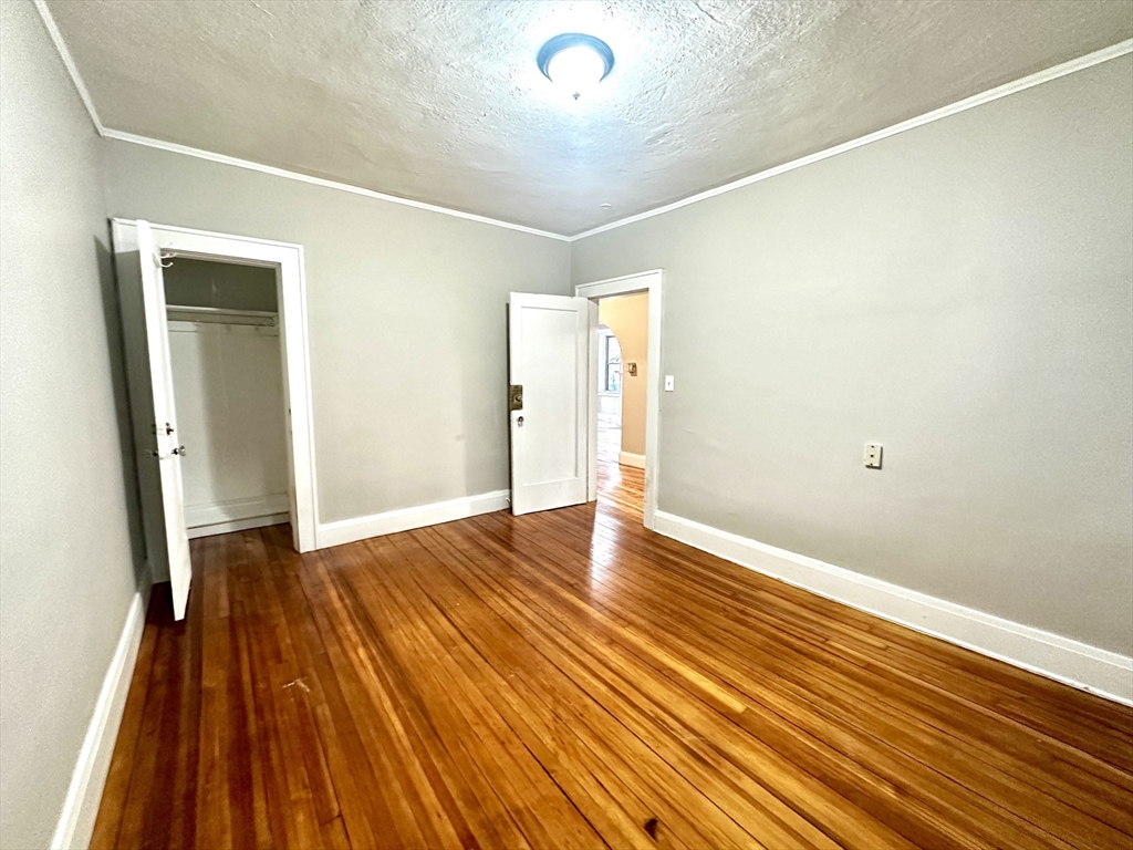 577 Pleasant Street, Unit 1L Holyoke, MA 01040 - Photo 20 of 24 a view of an empty room with wooden floor