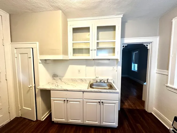 a kitchen with a sink and wooden floor