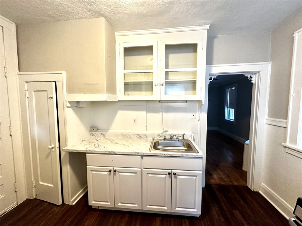 577 Pleasant Street, Unit 1L Holyoke, MA 01040 - Photo 3 of 24 a kitchen with a sink and wooden floor