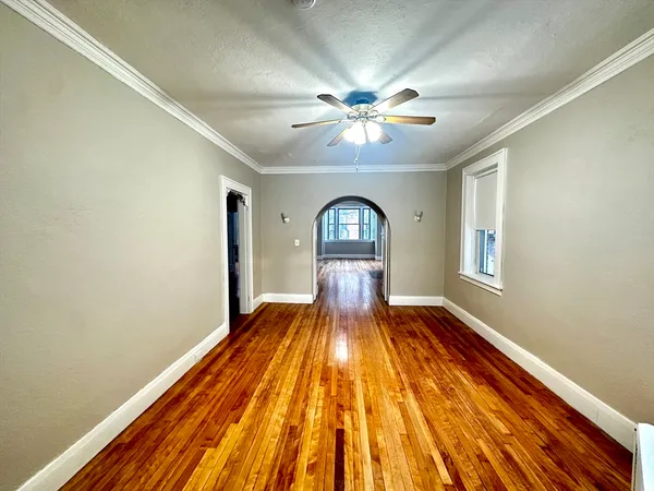 a view of empty room with wooden floor