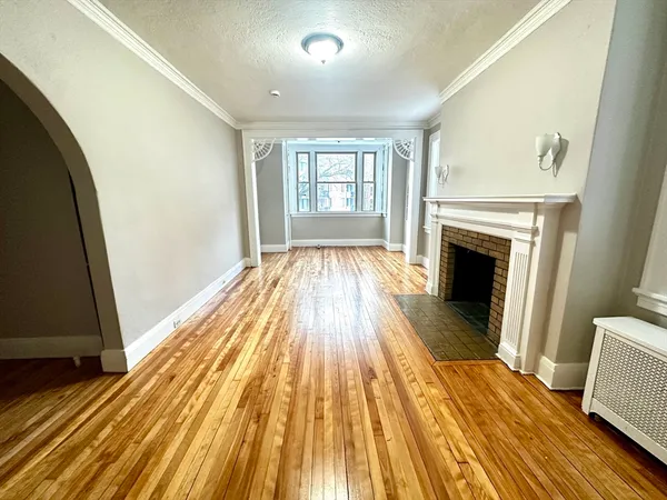 a view of a livingroom with wooden floor and fireplace