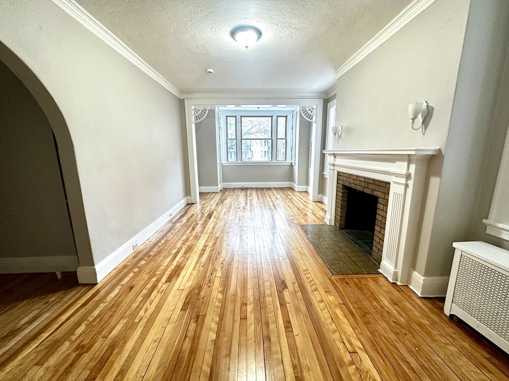 577 Pleasant Street, Unit 1L Holyoke, MA 01040 - Photo 9 of 24 a view of a livingroom with wooden floor and fireplace