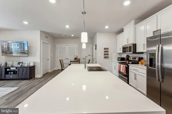 a large kitchen with stainless steel appliances kitchen island granite countertop a refrigerator a sink a stove and a sink