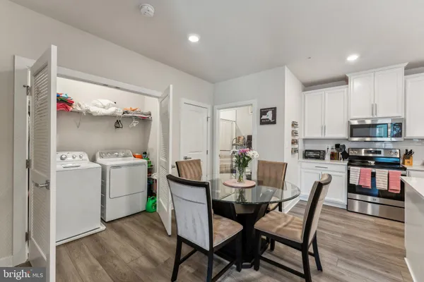 a kitchen with a dining table chairs and white cabinets