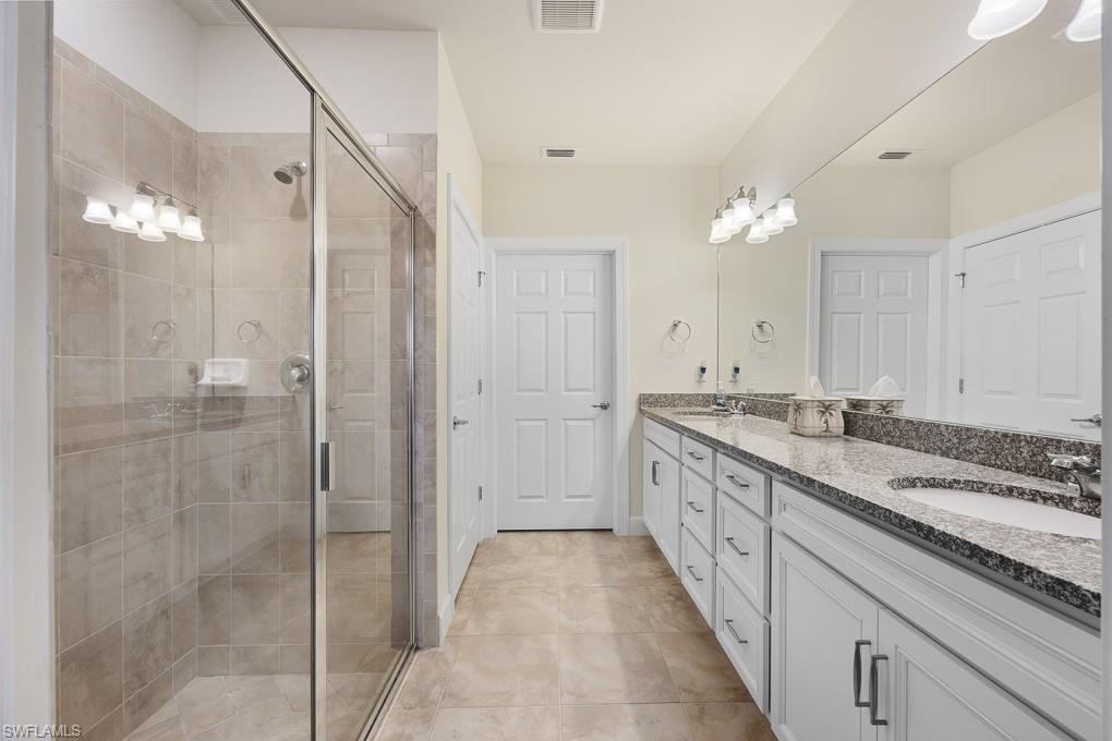 5698 Mayflower Way, Unit 403 Ave Maria, FL 34142 - Photo 17 of 27 a spacious bathroom with a granite countertop sink mirror and a shower