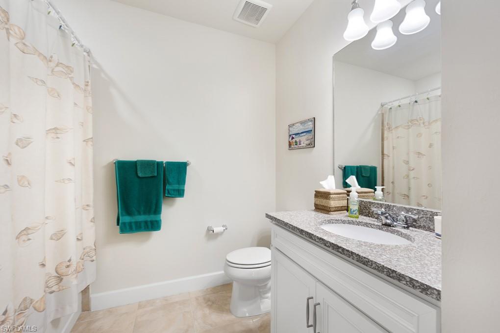 5698 Mayflower Way, Unit 403 Ave Maria, FL 34142 - Photo 5 of 27 a bathroom with a granite countertop toilet a sink and a mirror