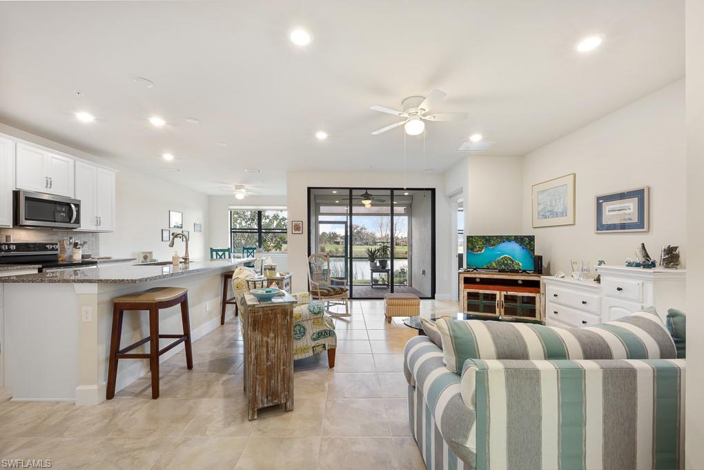 5698 Mayflower Way, Unit 403 Ave Maria, FL 34142 - Photo 8 of 27 a living room with furniture a large window and a kitchen view
