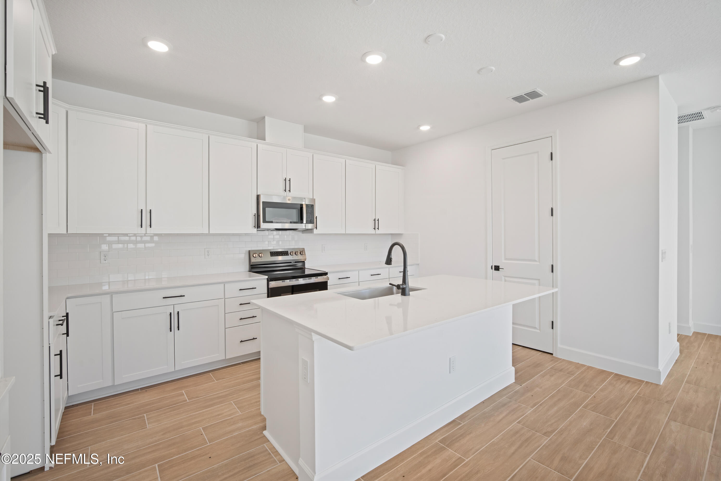 9253 Players Drive Weeki Wachee, FL 34613 - Photo 14 of 30 a kitchen with stainless steel appliances granite countertop a sink dishwasher a refrigerator and white cabinets with wooden floor