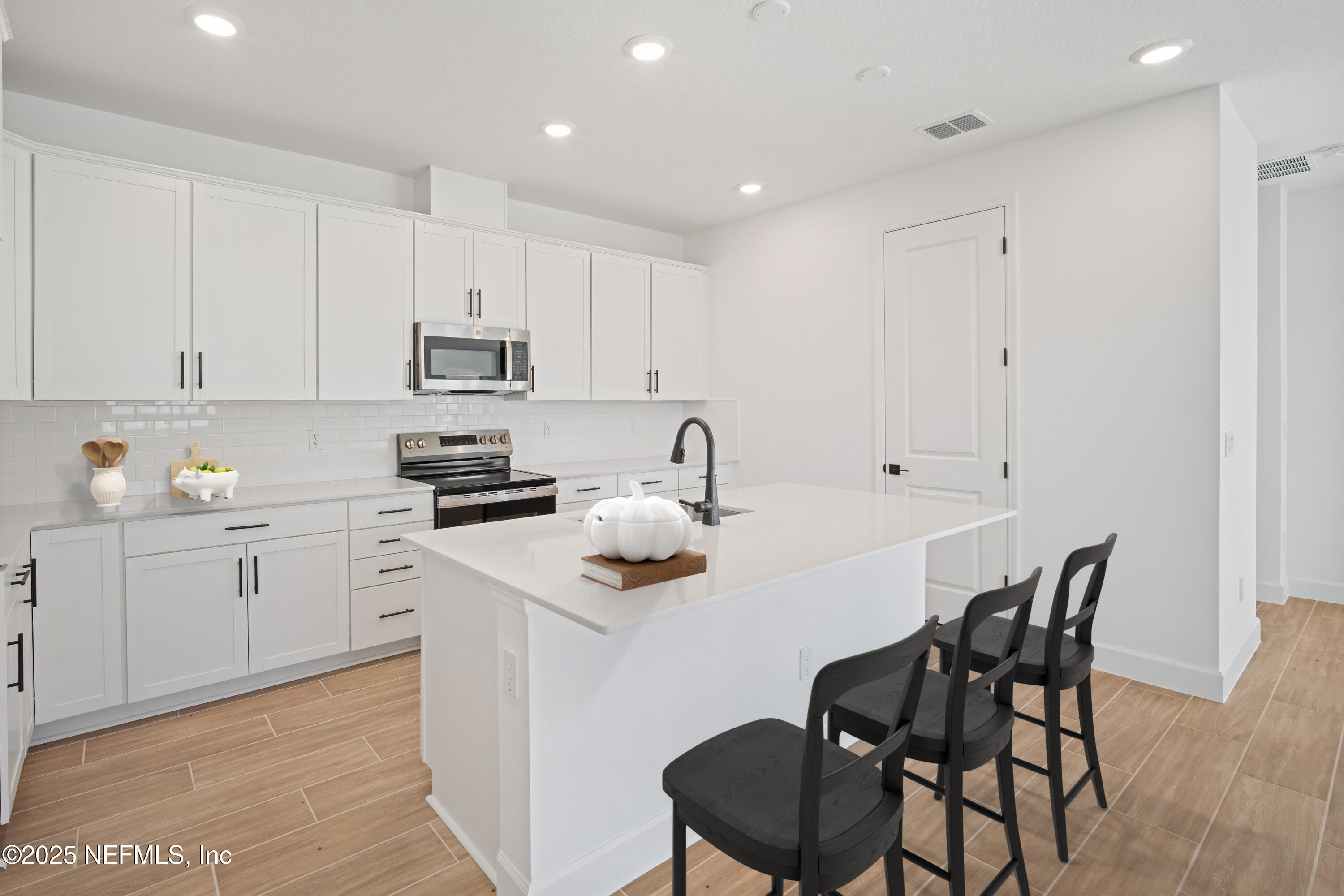 9253 Players Drive Weeki Wachee, FL 34613 - Photo 15 of 30 a kitchen with stainless steel appliances white cabinets a sink and a stove