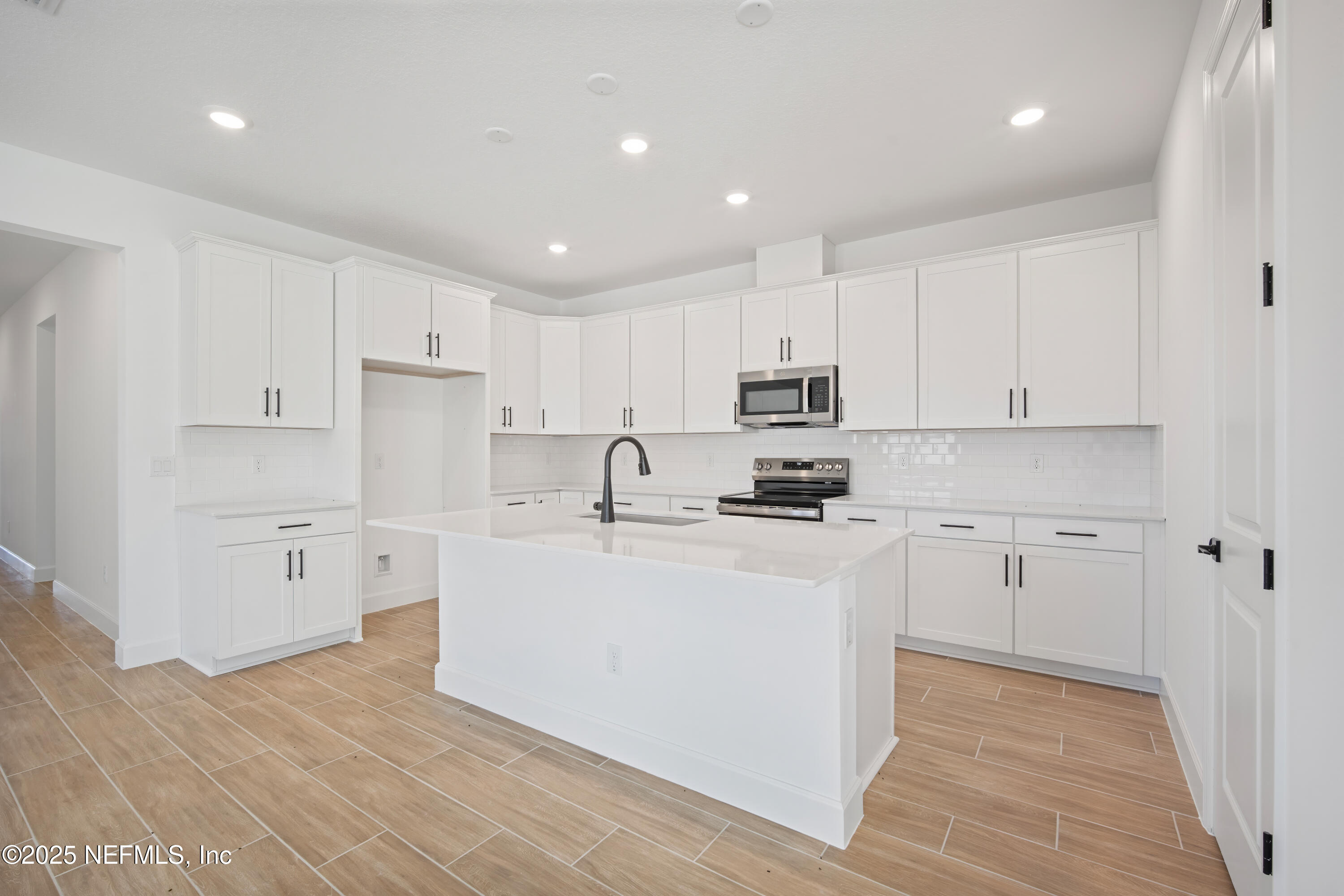 9253 Players Drive Weeki Wachee, FL 34613 - Photo 16 of 30 a kitchen with white cabinets and white appliances