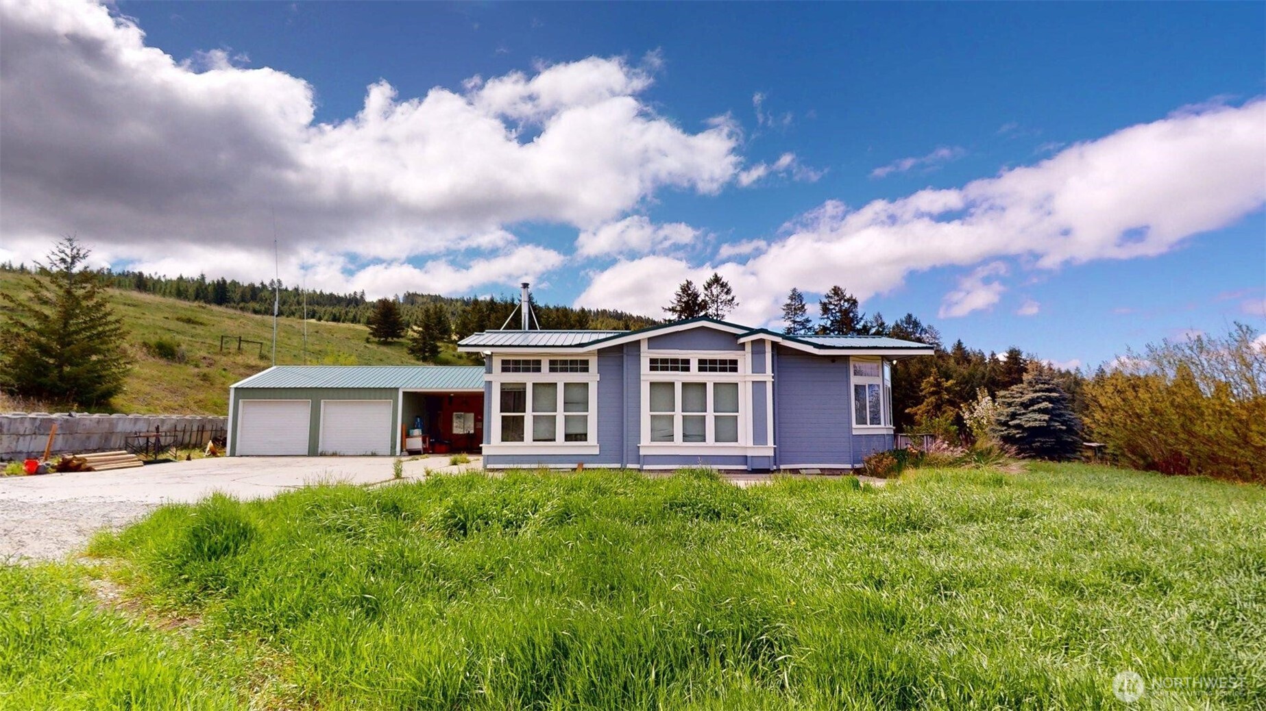 142 Fletcher Road Oroville, WA 98844 - Photo 2 of 26 a view of a house with a big yard and large trees
