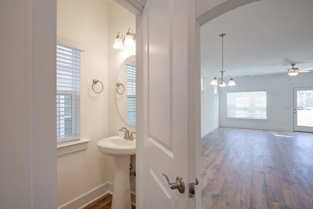 a view of a hallway with windows and chandelier