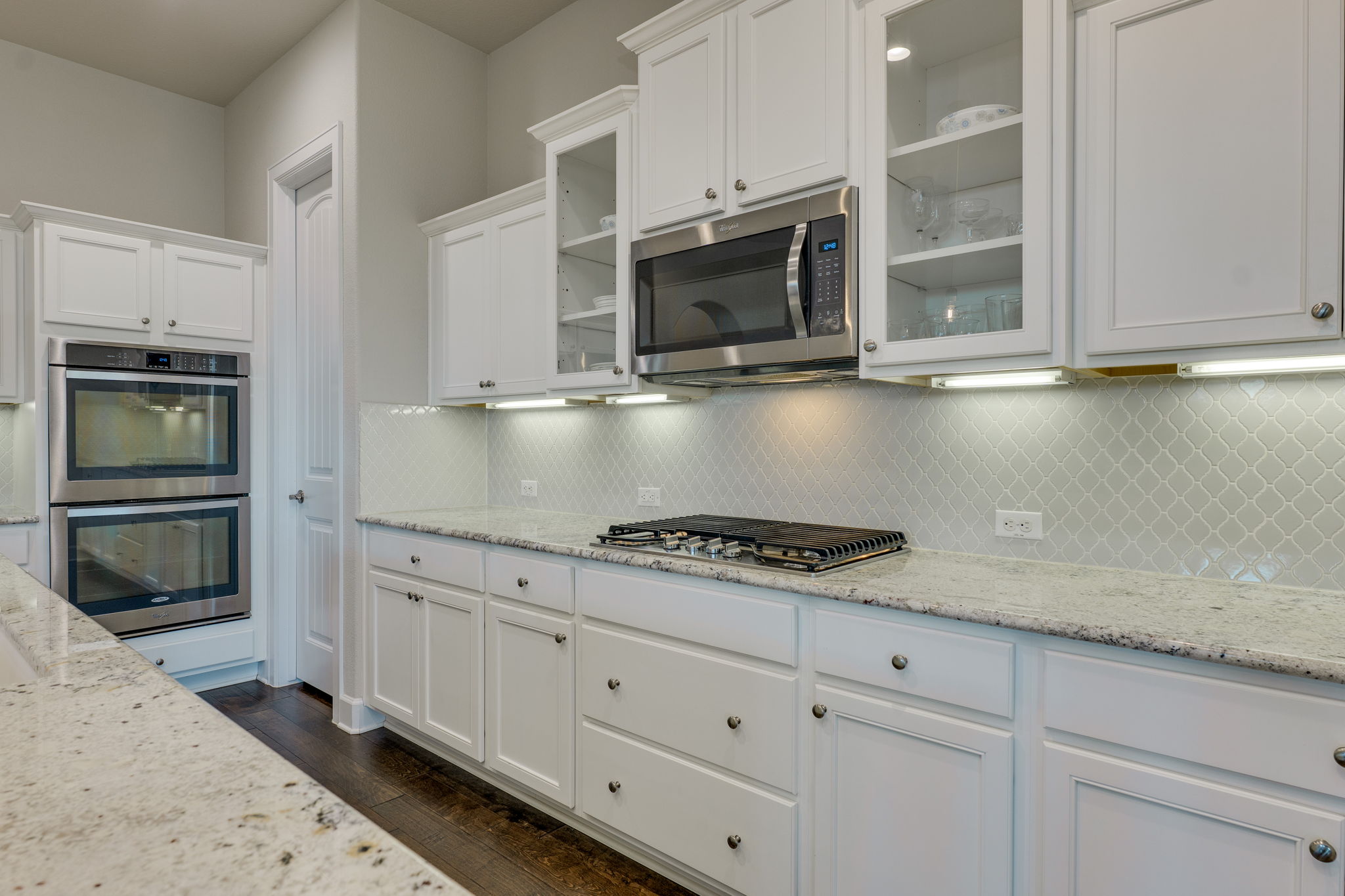 3300 Venezia View Leander, TX 78641 - Photo 8 of 33 Double ovens, under cabinet lights and glass inserts; granite counters; pot drawers