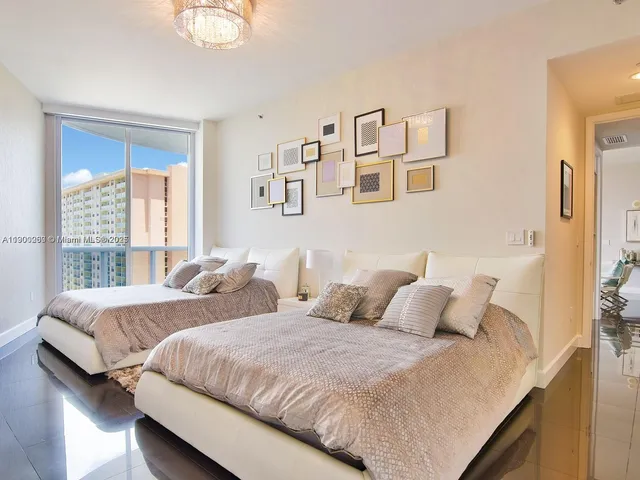 a bedroom with two beds and a large window