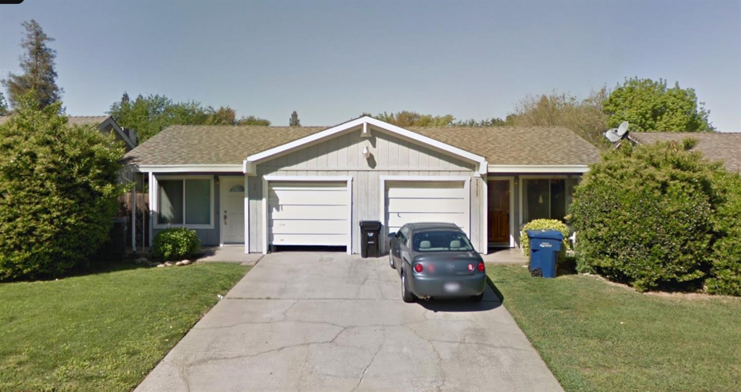 a view of a house with a small yard and a car parked in front of it