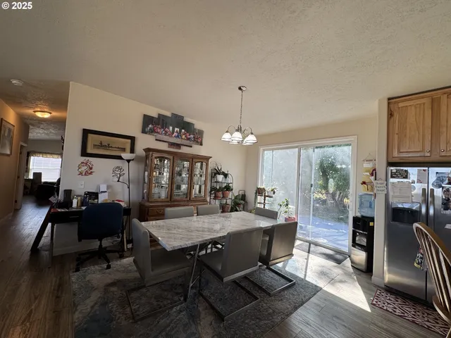 a dining room with wooden floor a chandelier a wooden table and chairs