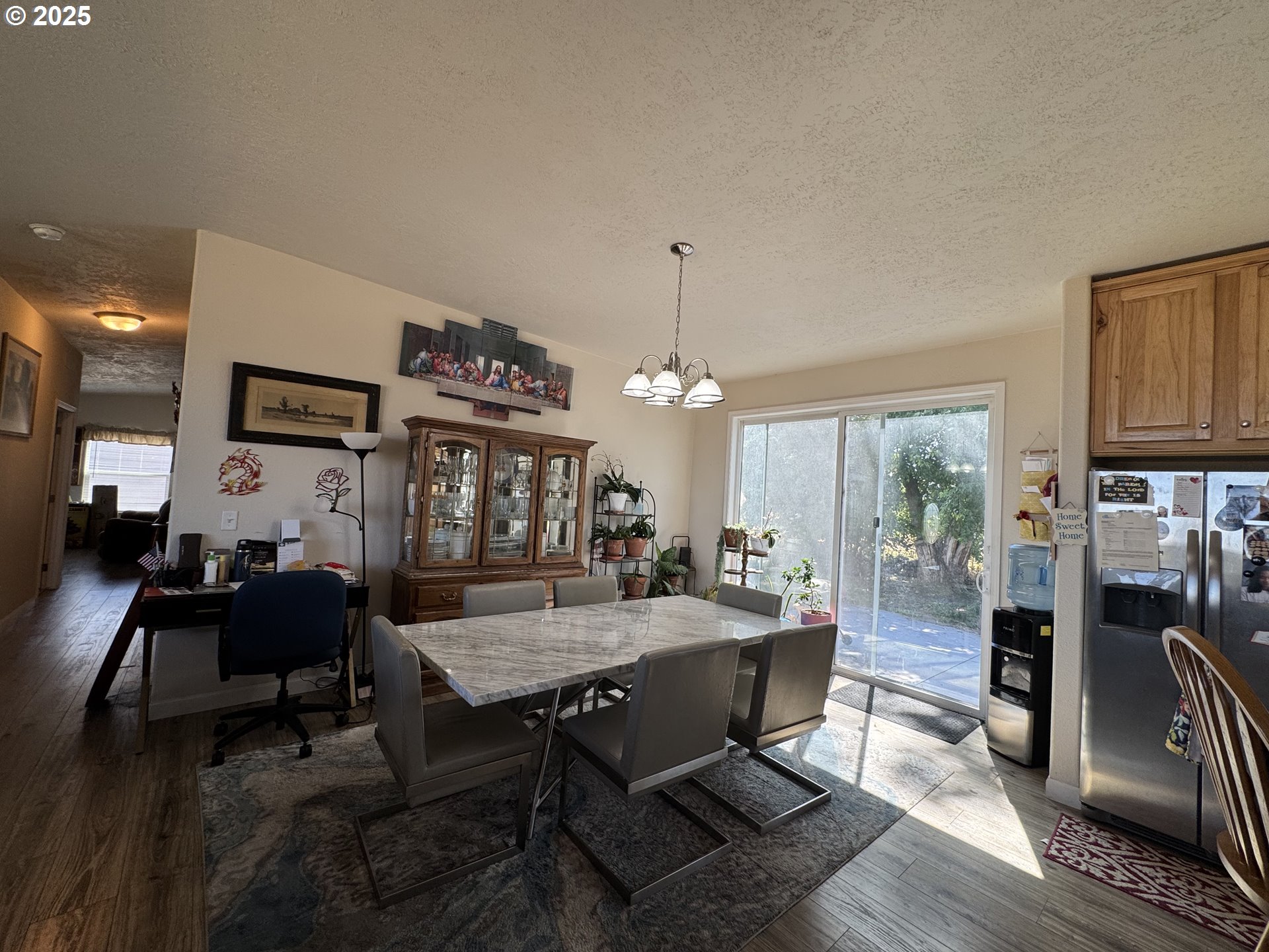 70753 Quail Lane Boardman, OR 97818 - Photo 7 of 26 a dining room with wooden floor a chandelier a wooden table and chairs