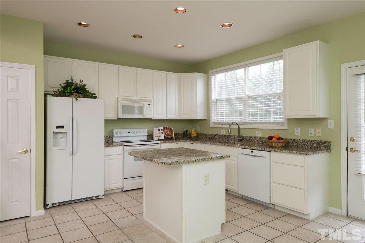 5222 Echo Ridge Road Raleigh, NC 27612 - Photo 15 of 25 a kitchen with granite countertop white cabinets white appliances a sink and a window