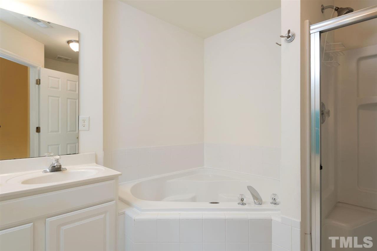5222 Echo Ridge Road Raleigh, NC 27612 - Photo 19 of 25 a bathroom with a tub sink and mirror
