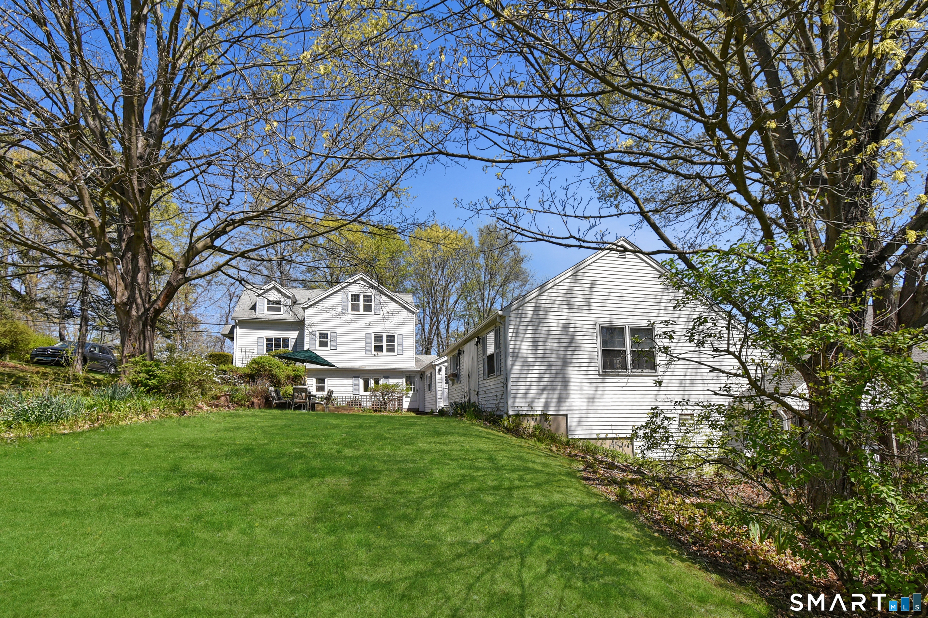 213 Hart Street Berlin, CT 06037 - Photo 5 of 40 a view of a white house with a big yard plants and large trees