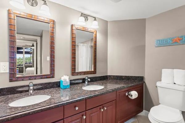 a bathroom with a granite countertop toilet sink and mirror