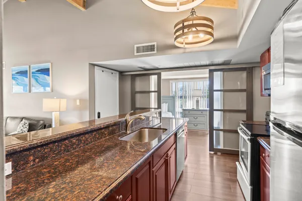 a kitchen with granite countertop a sink and a stove