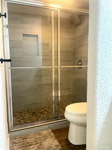 a bathroom with a toilet and a shower