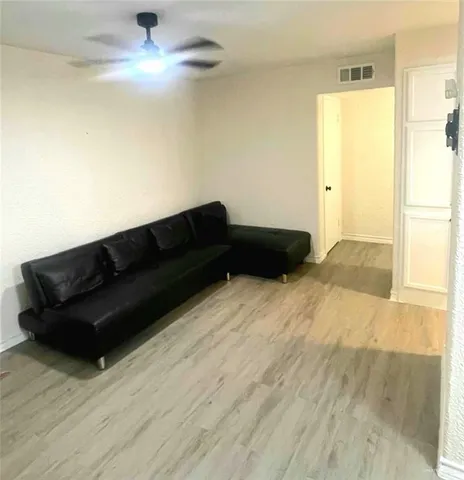 a living room with furniture and a ceiling fan