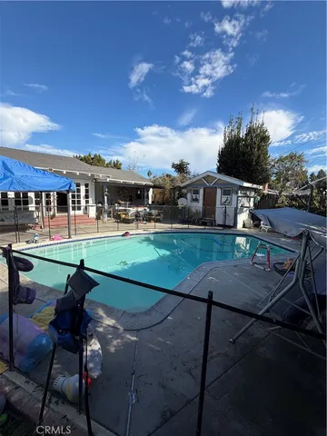 a view of a swimming pool with lawn chairs and floor to ceiling window