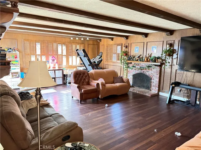 a living room with furniture floor to ceiling window and a flat screen tv