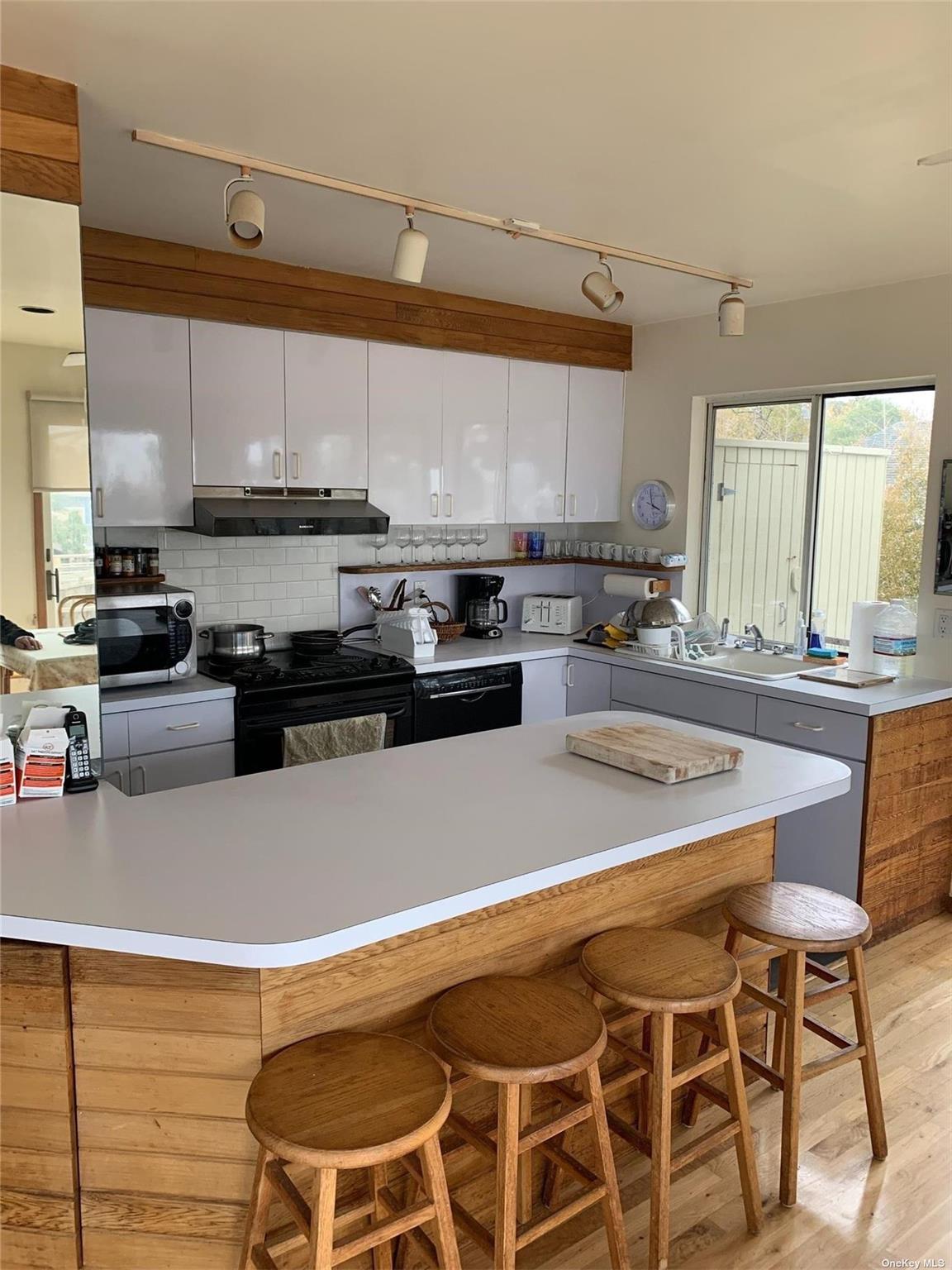 6 Sloop Walk Ocean Beach, NY 11770 - Photo 4 of 11 a kitchen with a stove a sink and a microwave