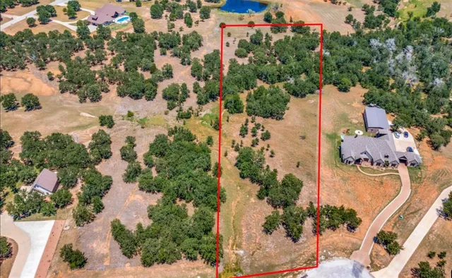 an aerial view of residential house with outdoor space and trees all around