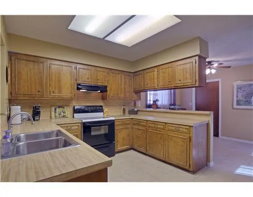 a kitchen with stainless steel appliances granite countertop a stove top oven a sink dishwasher and cabinets with wooden floor