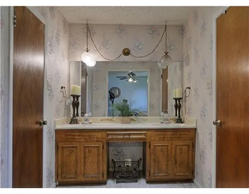 a bathroom with a granite countertop sink a mirror and a shower