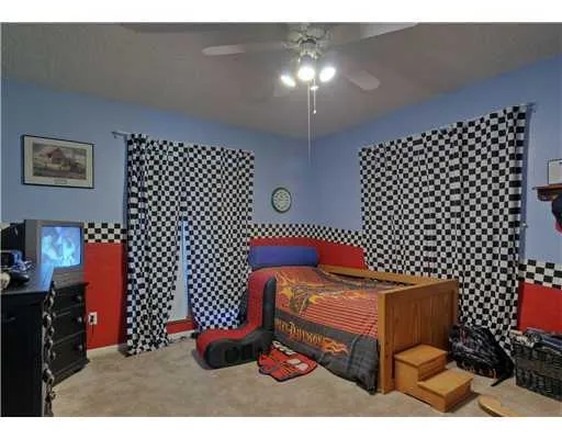 a bedroom with a bed and a lamp on dresser