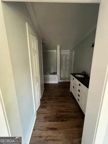 a view of a hallway with wooden floor and staircase