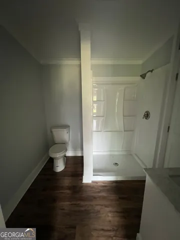 a bathroom with a toilet and a shower