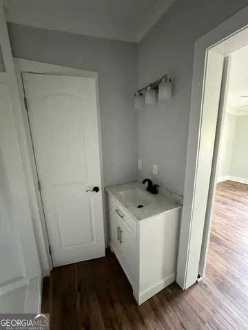 a storage room with a washer dryer and wooden floor