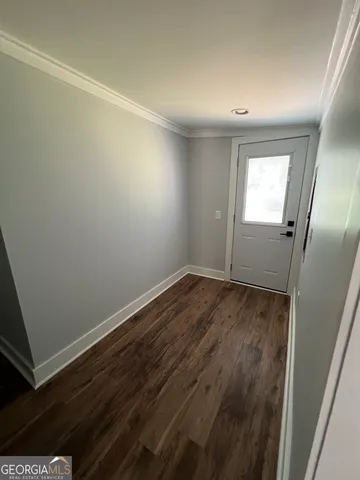 an empty room with wooden floor and mirror