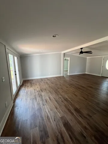 a view of empty room with wooden floor