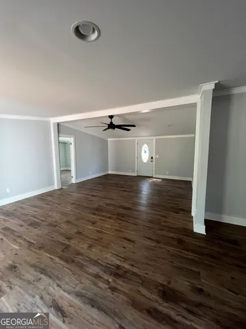 a view of empty room with wooden floor