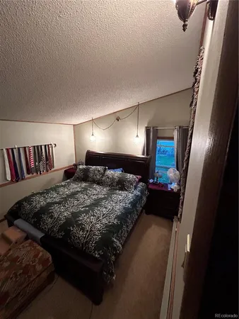a bed sitting in a bedroom next to a lamp