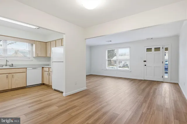 a view of a kitchen with wooden floors and white walls
