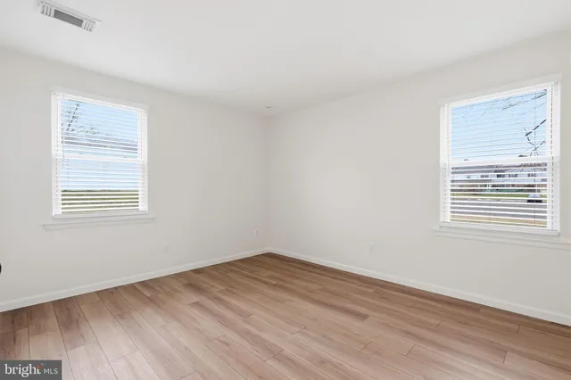 a view of a room with wooden floor and windows